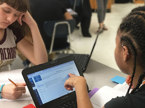 Student pointing at computer screen.